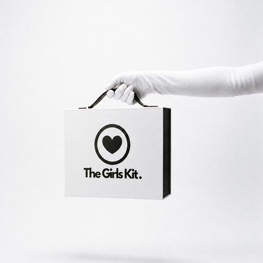 Hand holding a box labeled 'The Girls Kit' on a white background